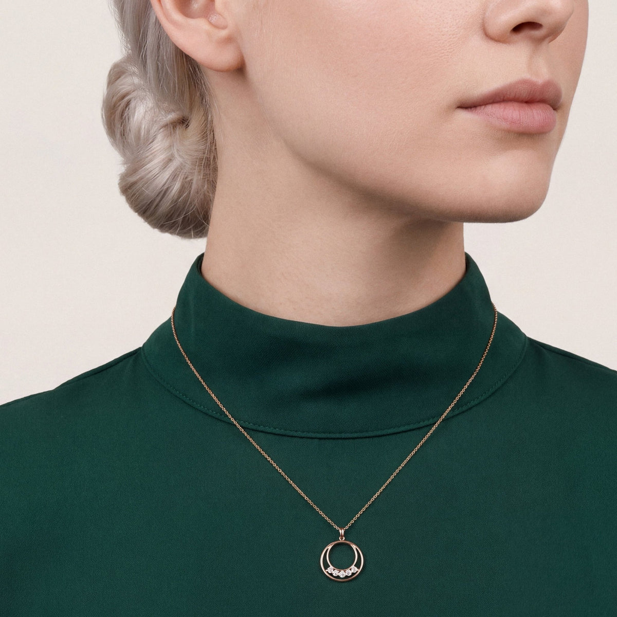 Model in an emerald crepe funnel-neck top wearing a 0.19 ct tw natural diamond double circle pendant necklace in 14K rose gold