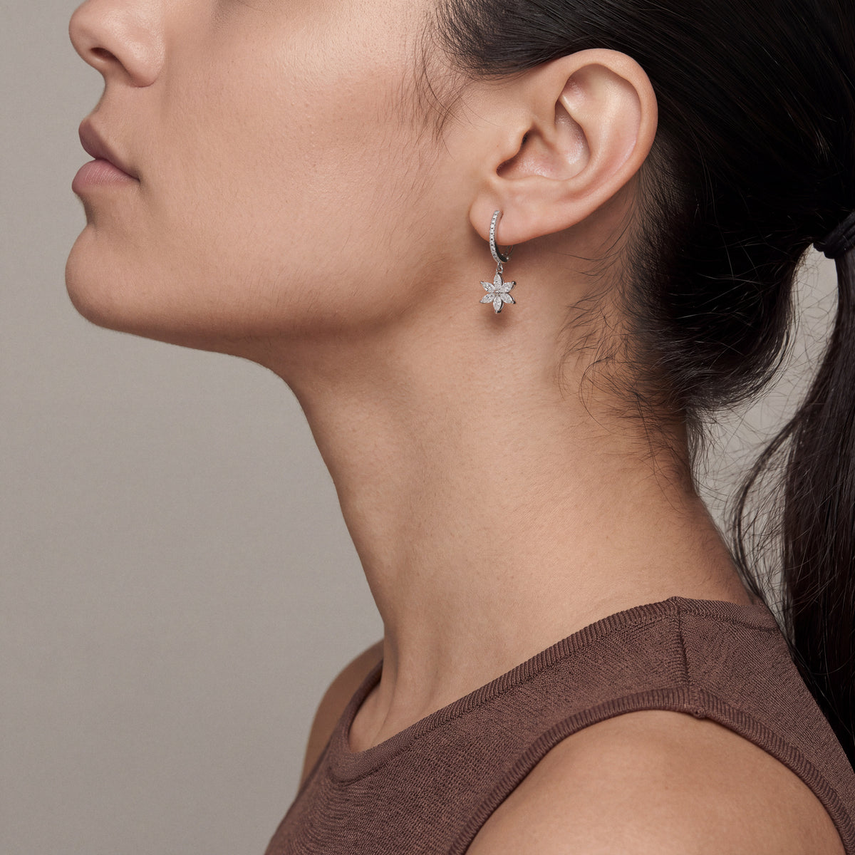 Second model wearing the marquise diamond flower drop earring, profile with the chin lifted
