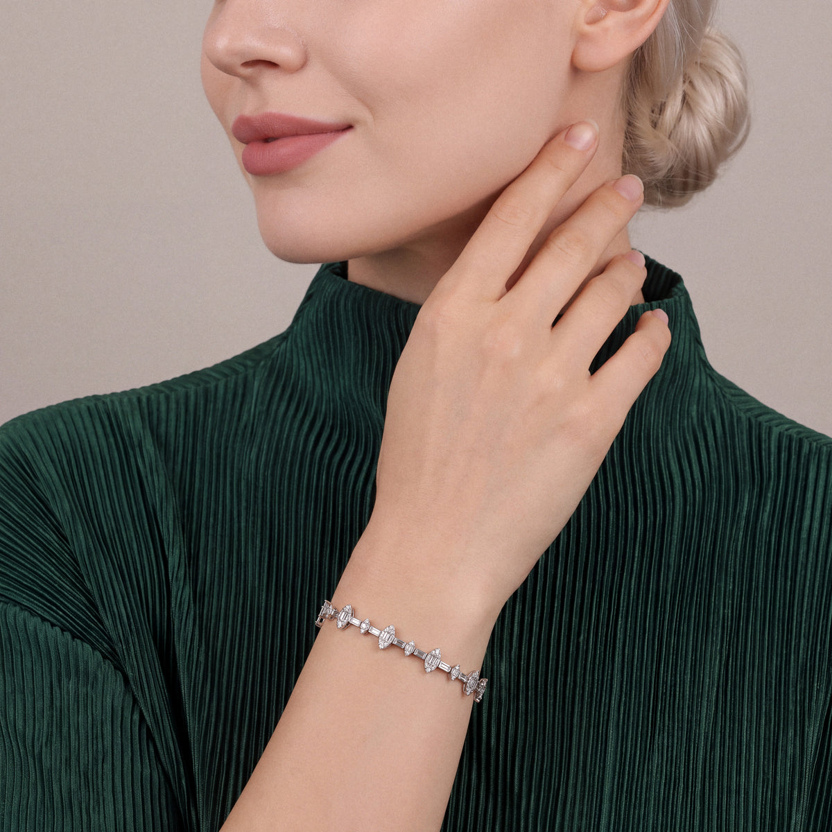 Woman in an emerald pleated top wearing a natural diamond baguette marquise cluster bracelet in 14K white gold