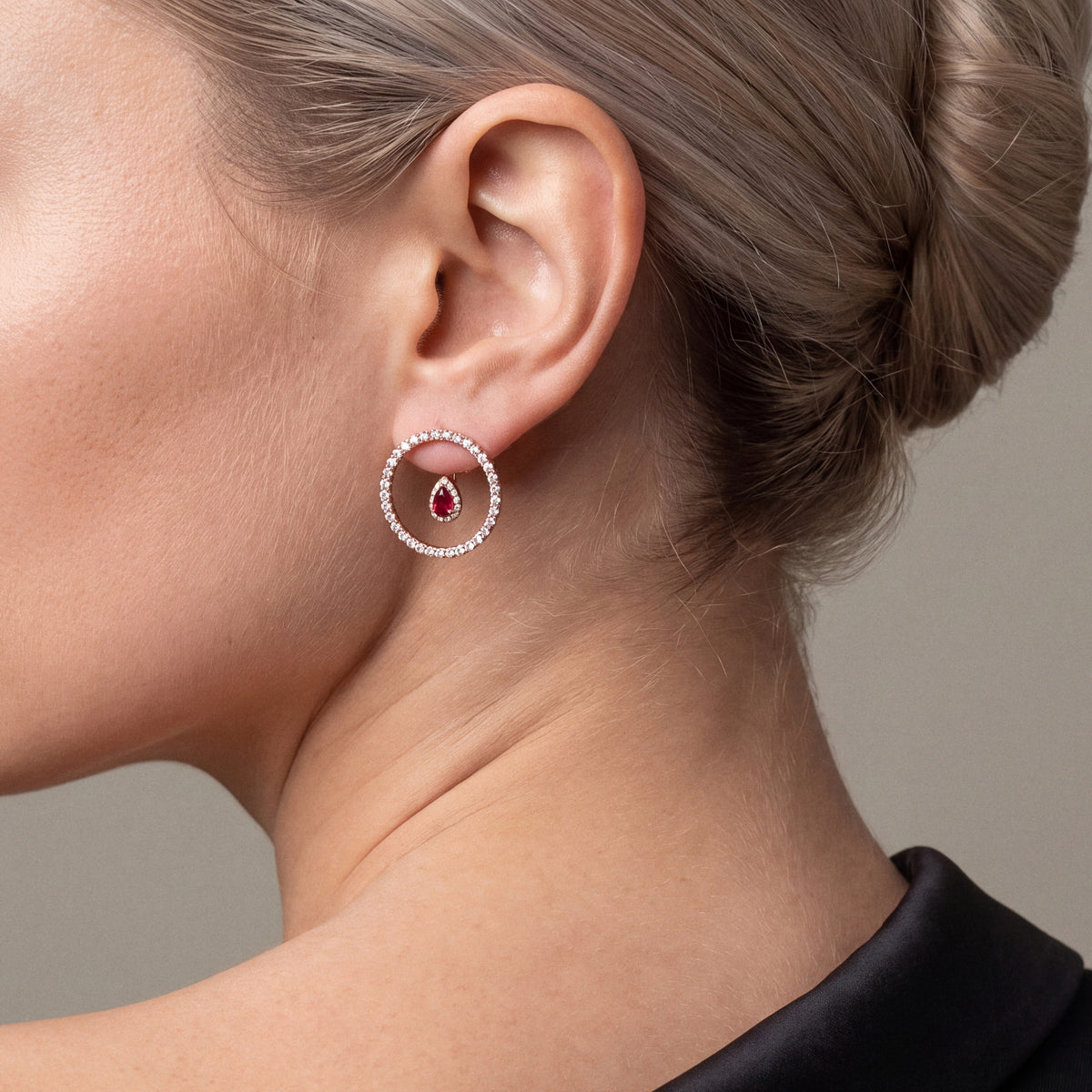 1.85 ct ruby and diamond open circle earring in 14K rose gold, worn with a black satin-lapel tuxedo off the shoulder