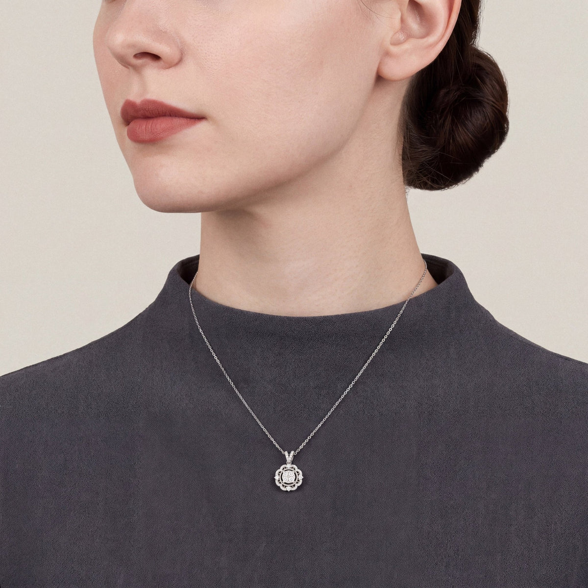 Woman in a charcoal crepe funnel-neck top wearing a 0.47 ct tw natural diamond scalloped halo pendant necklace in 14K white gold