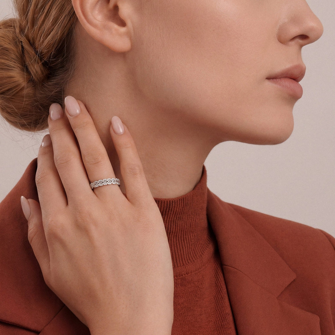 Woman in a rust blazer and mock neck wearing a 0.44 ct tw natural diamond braided baguette half eternity ring in 14K white gold