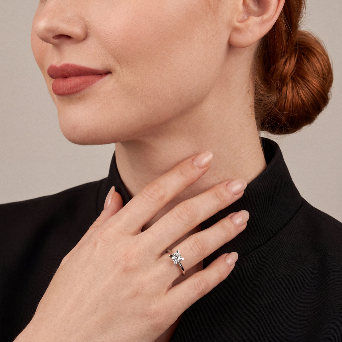 Woman in a black silk-faille stand-collar jacket wearing a 0.60 ct natural diamond petal-claw solitaire ring in 14K white gold