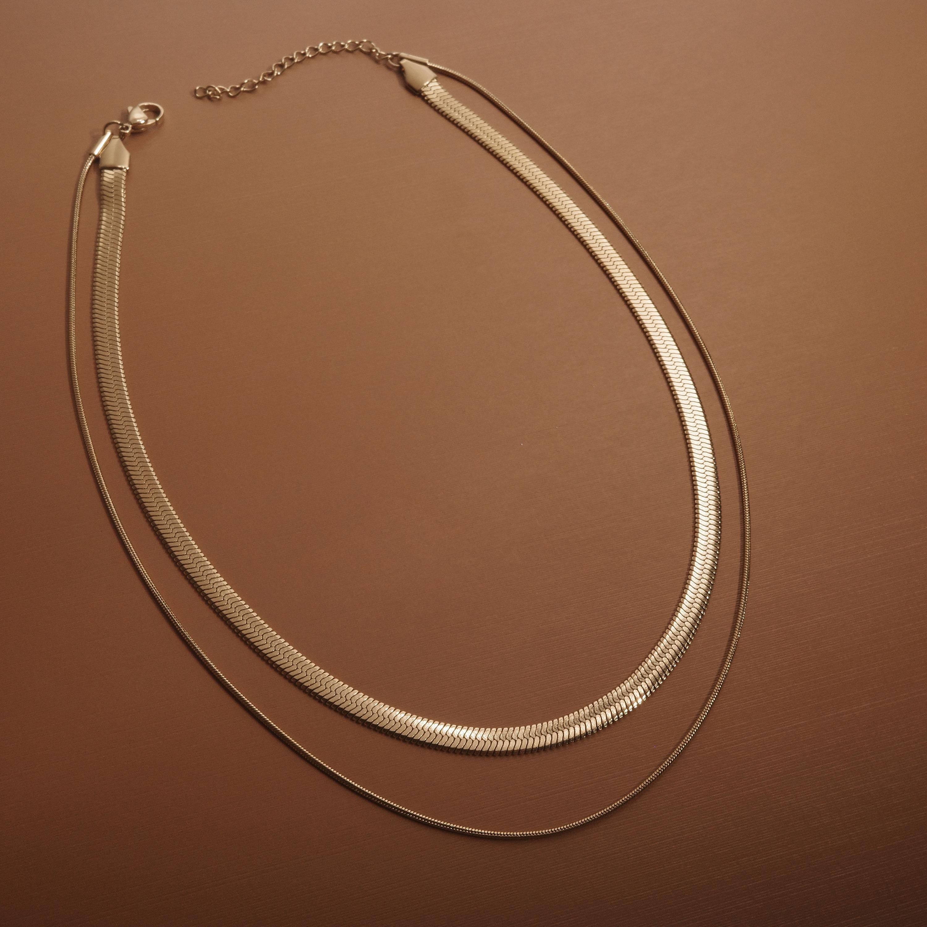 The Layered Herringbone and Snake Necklace worn in Gold-Plated Steel — refined accessory for women. Hypoallergenic, no.