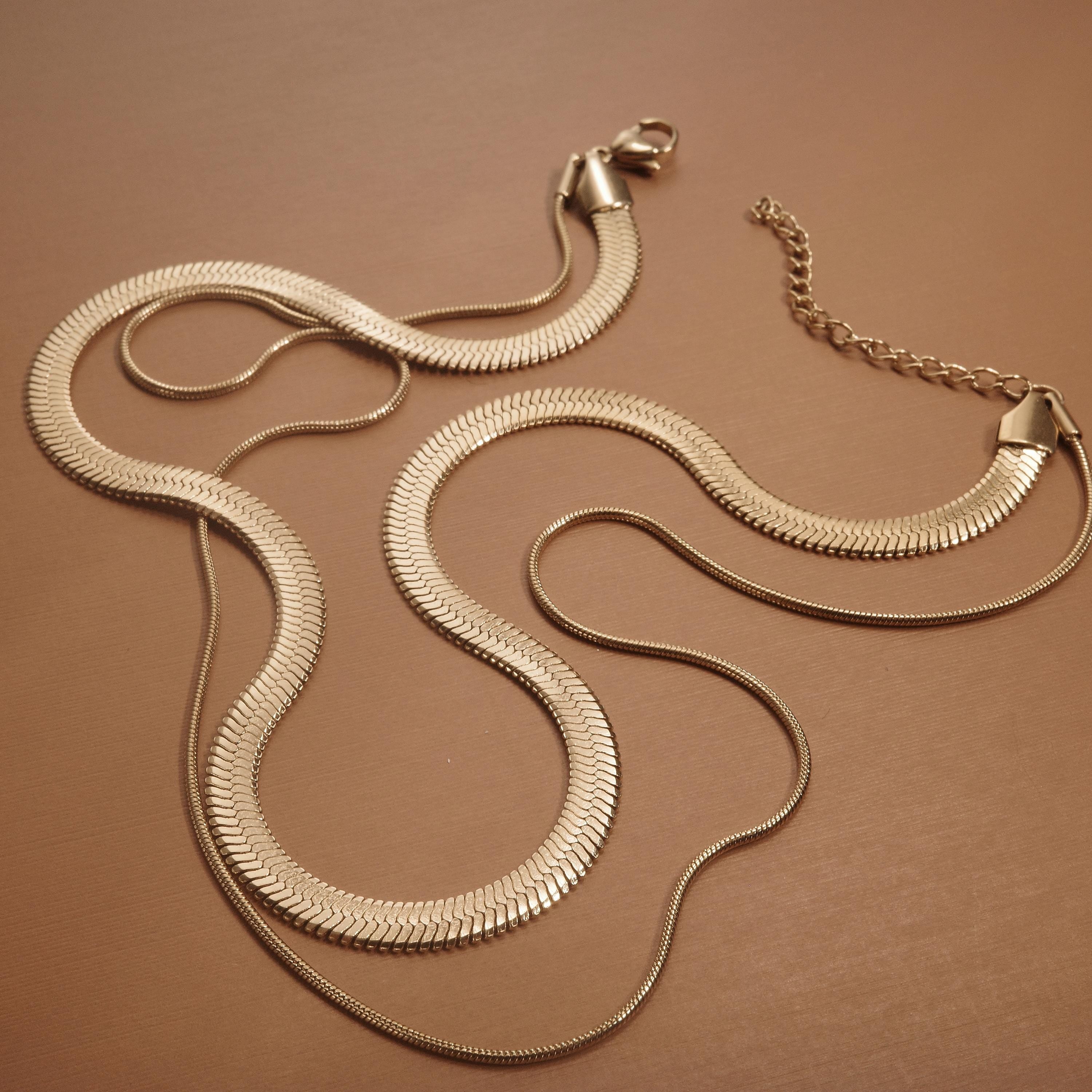 Layered Herringbone and Snake Necklace styled with complementary pieces in Gold-Plated Steel. Tarnish-resistant, layered.