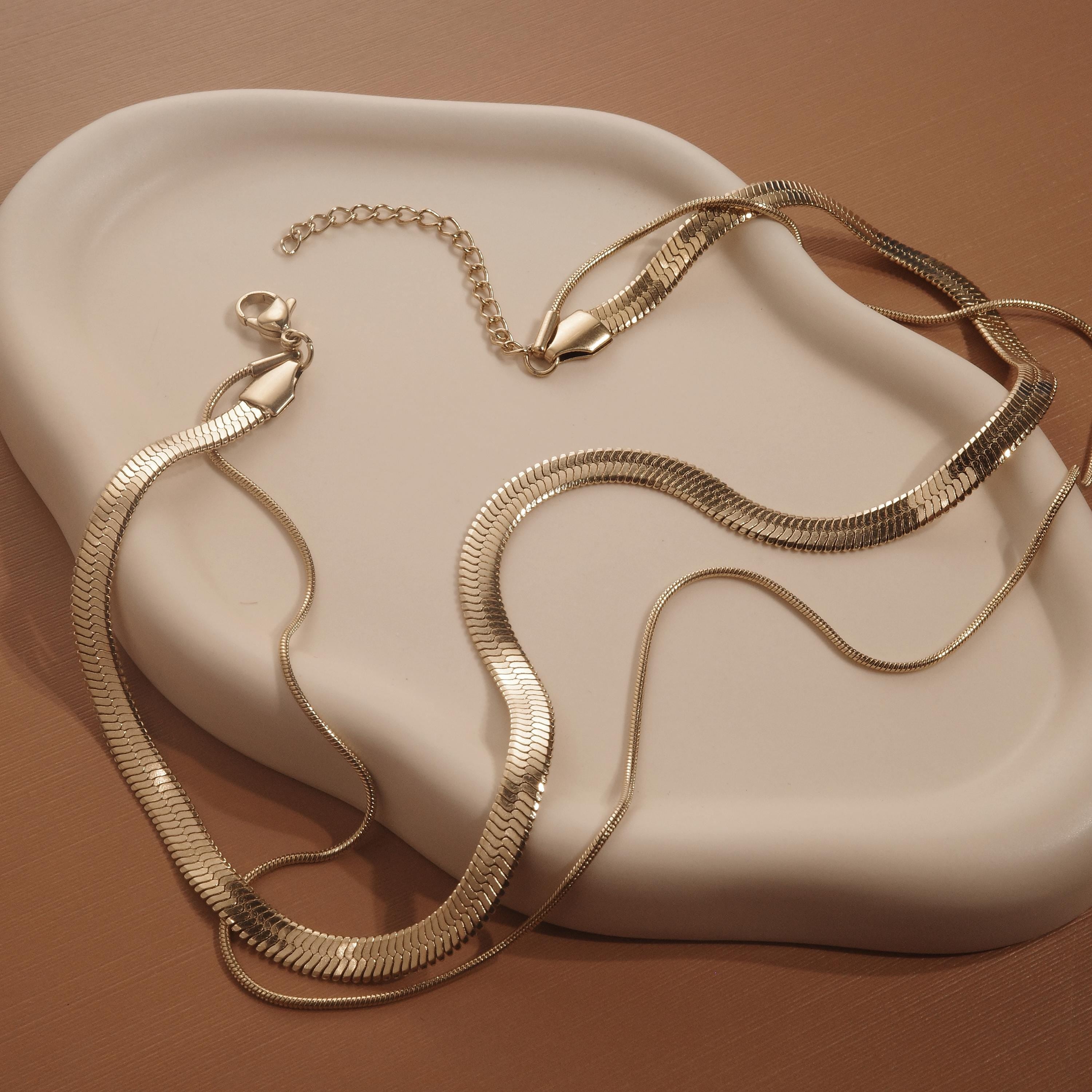 Macro detail of the Layered Herringbone and Snake Necklace showcasing craftsmanship in Gold-Plated Steel.