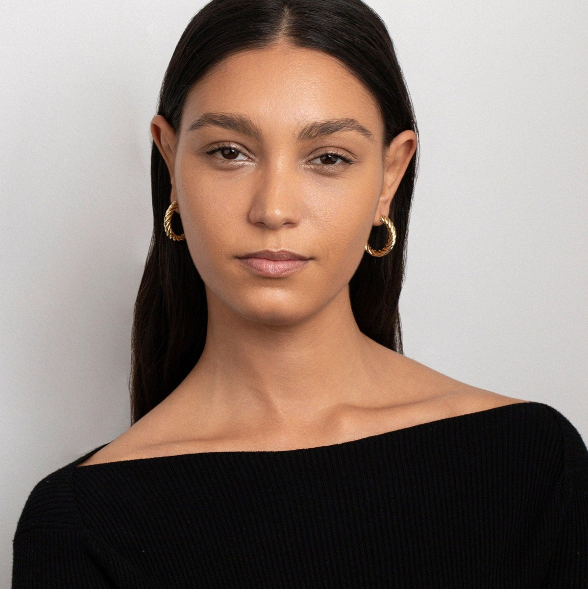 The Twisted Hoop Earrings styled in Gold-Plated Steel — elegant everyday jewelry. Hypoallergenic for sensitive ears.