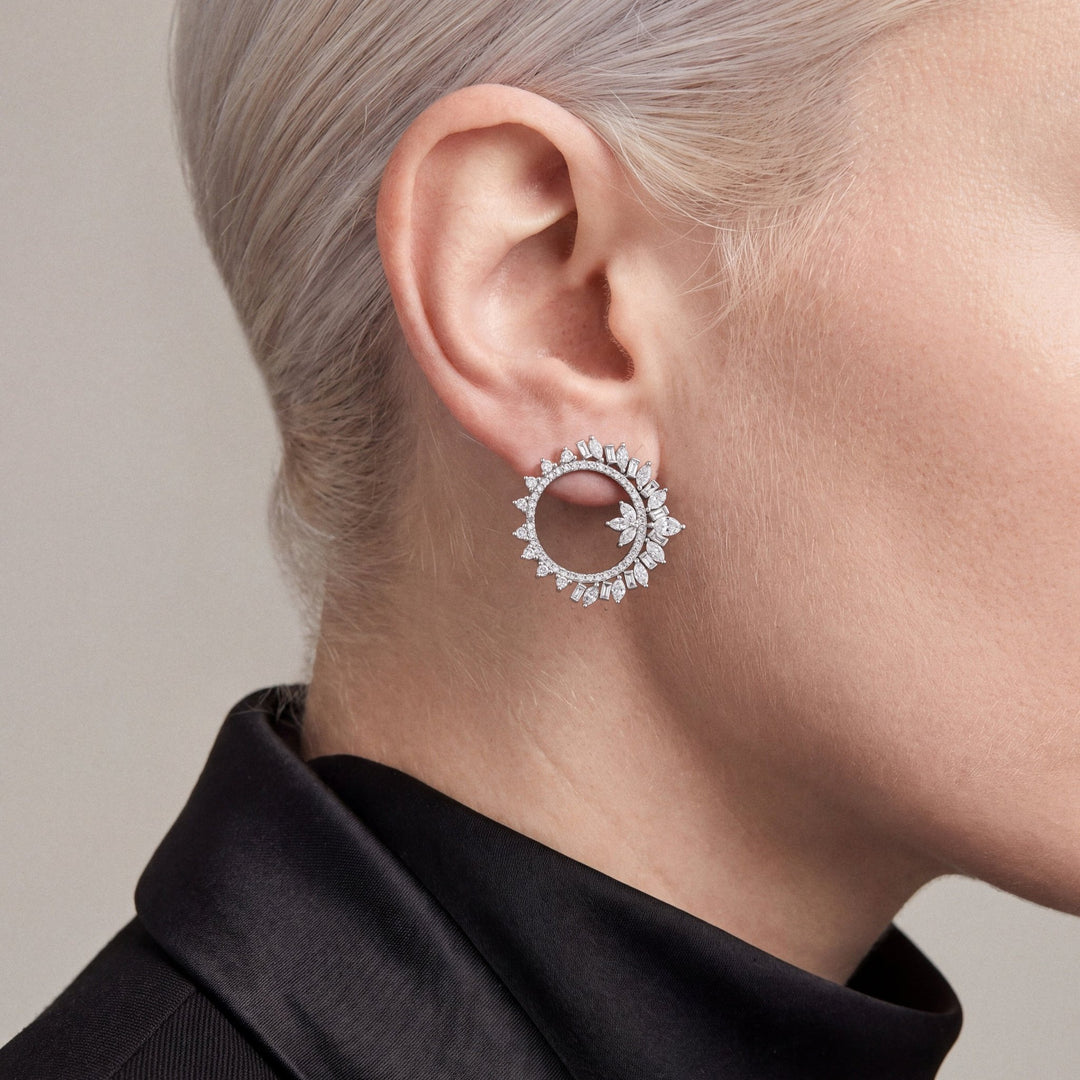 Woman in a black tuxedo jacket wearing a 2.43 ct tw natural diamond marquise and baguette open circle earring in 14K white gold.