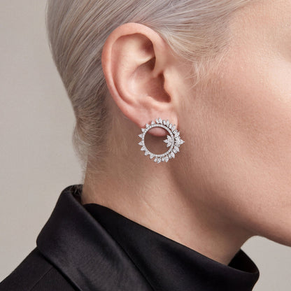 Woman in a black tuxedo jacket wearing a 2.43 ct tw natural diamond marquise and baguette open circle earring in 14K white gold.