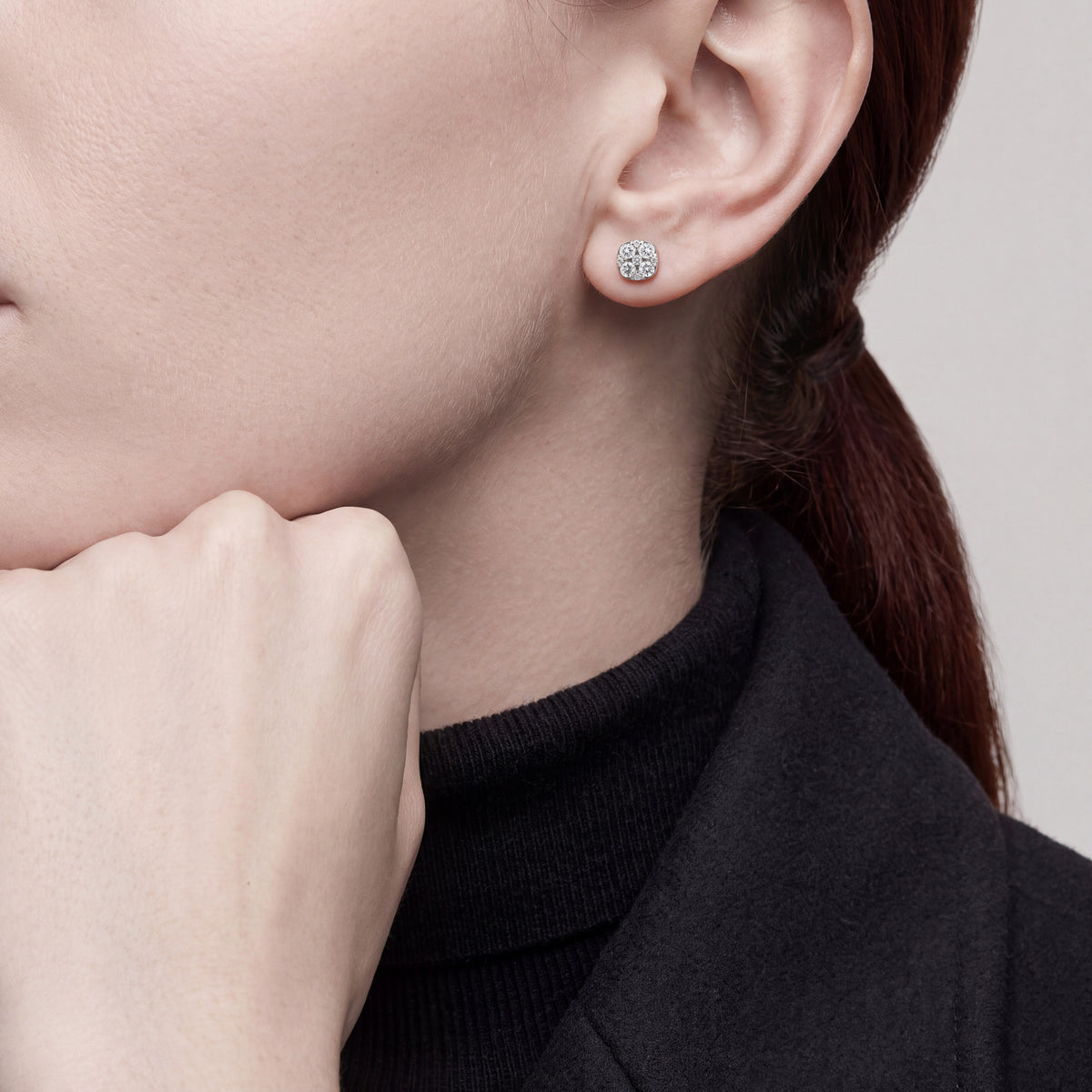 Model wearing 0.27 ct natural diamond cluster stud earrings in 14K white gold, hand resting under chin