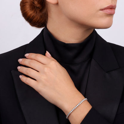 Woman in a black satin-lapel tuxedo jacket wearing a 6.68 ct tw natural diamond tennis bracelet in 14K white gold