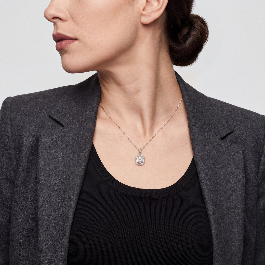 Model wearing the Art Deco baguette natural diamond halo necklace in 14K solid white gold with a charcoal blazer over a black top