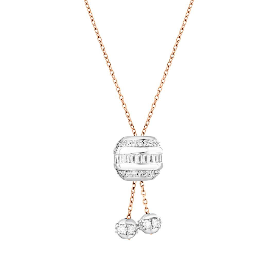 Close-up of the white-gold diamond barrel with upright baguettes and round brilliants on a rose-gold lariat chain with two diamond ball drops