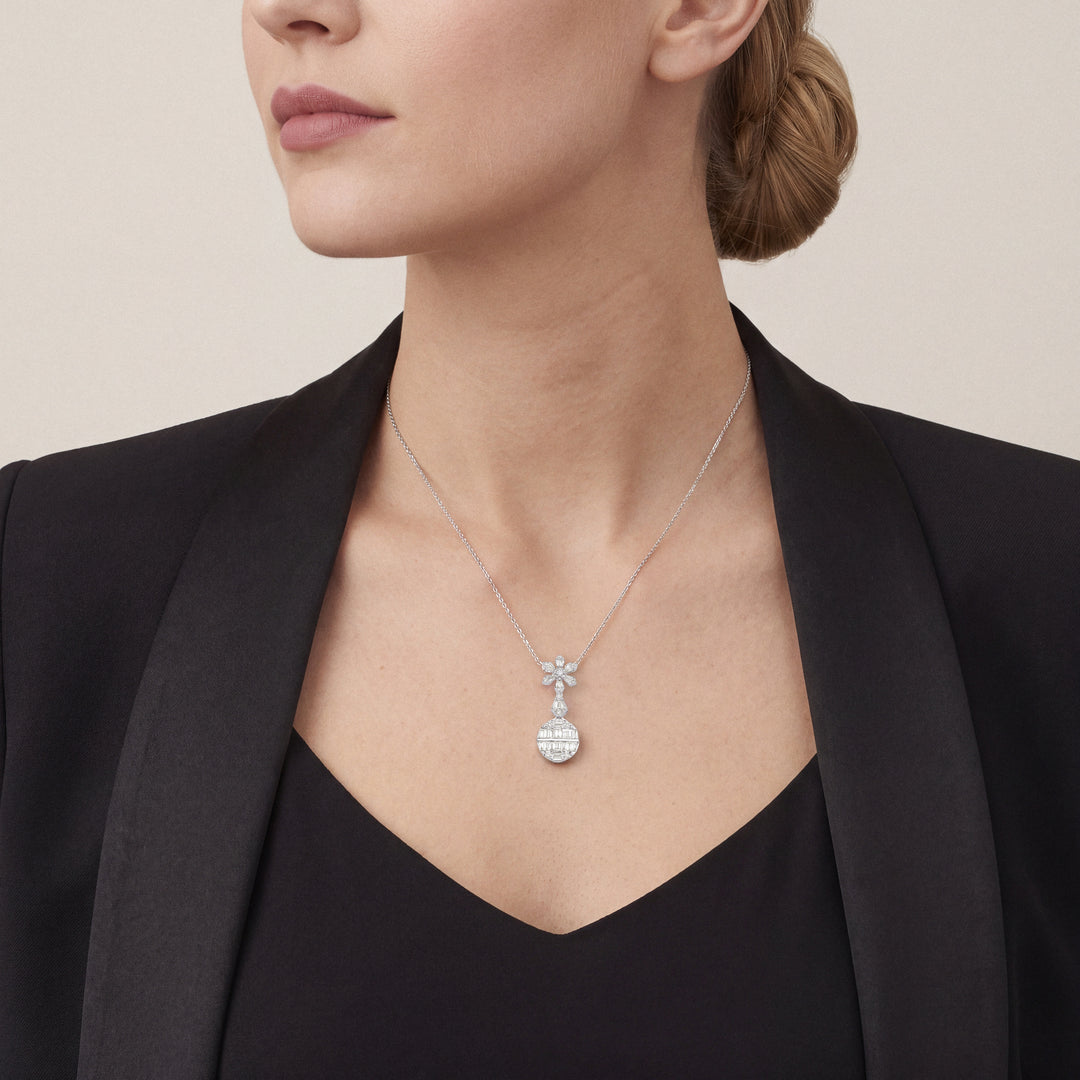 Woman in a black tuxedo jacket wearing the baguette natural diamond flower drop pendant necklace in 14K white gold
