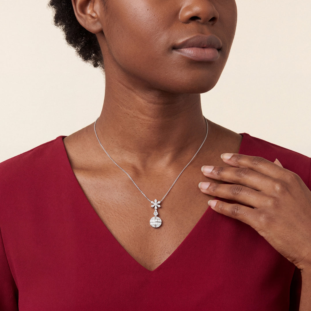Woman in a red crepe top wearing the baguette natural diamond flower drop pendant necklace in 14K white gold
