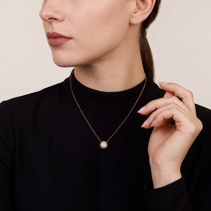 Model in a black crepe mock-neck top wearing a 0.13 ct natural diamond pavé disc pendant necklace in 14K rose and white gold