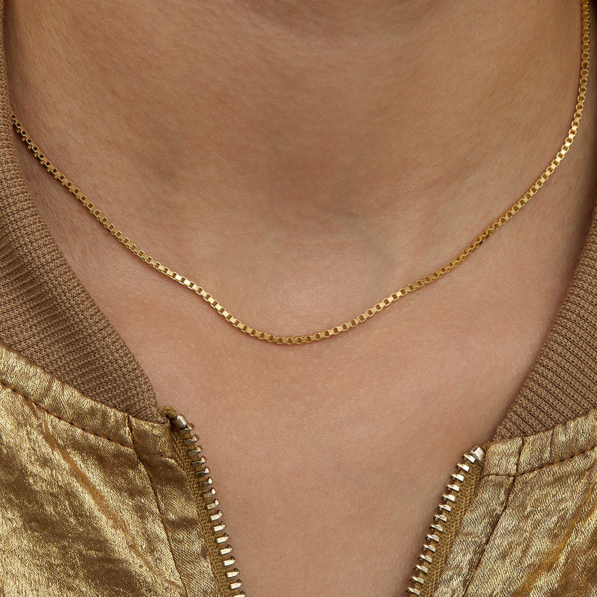 Close view of the Box Chain Necklace on the neck — 1.3 mm square links in gold.