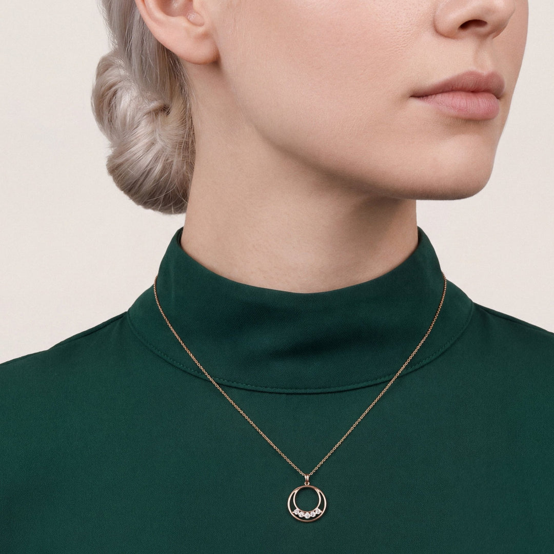 Model in an emerald crepe funnel-neck top wearing a 0.19 ct tw natural diamond double circle pendant necklace in 14K rose gold