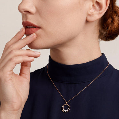 Model in a navy crepe mock-neck top wearing a 0.19 ct tw natural diamond double circle pendant necklace in 14K rose gold