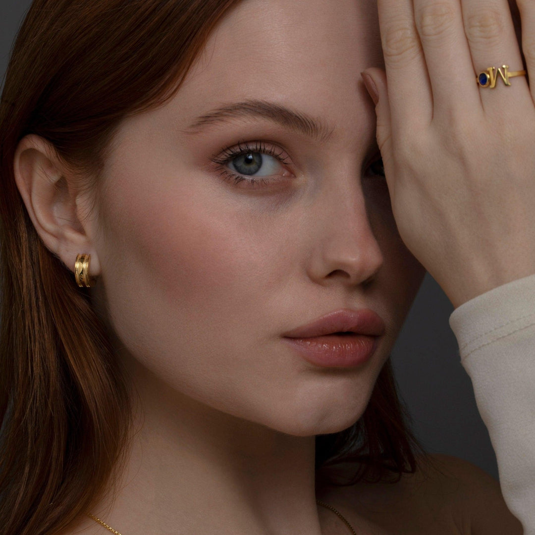 The Dainty Huggie Hoop Earrings styled in 18K Gold Vermeil — elegant everyday jewelry. Hypoallergenic for sensitive ears.