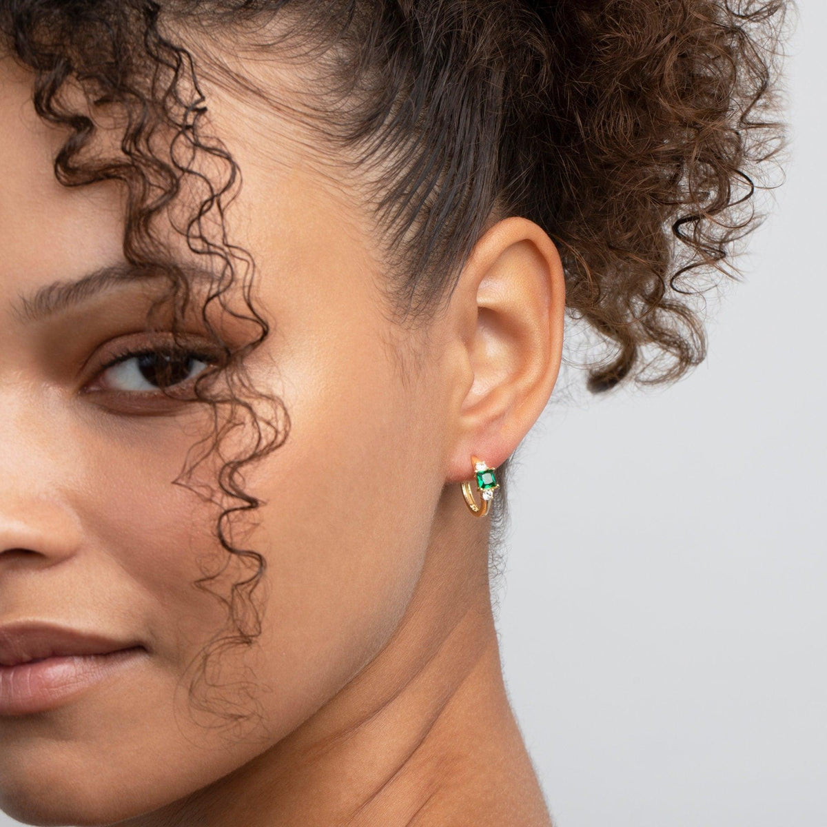 Close detail of the Emerald Hoop Dangle Earrings in 18K Gold Vermeil with CZ Diamond and Emerald (CZ). Tarnish-resistant.