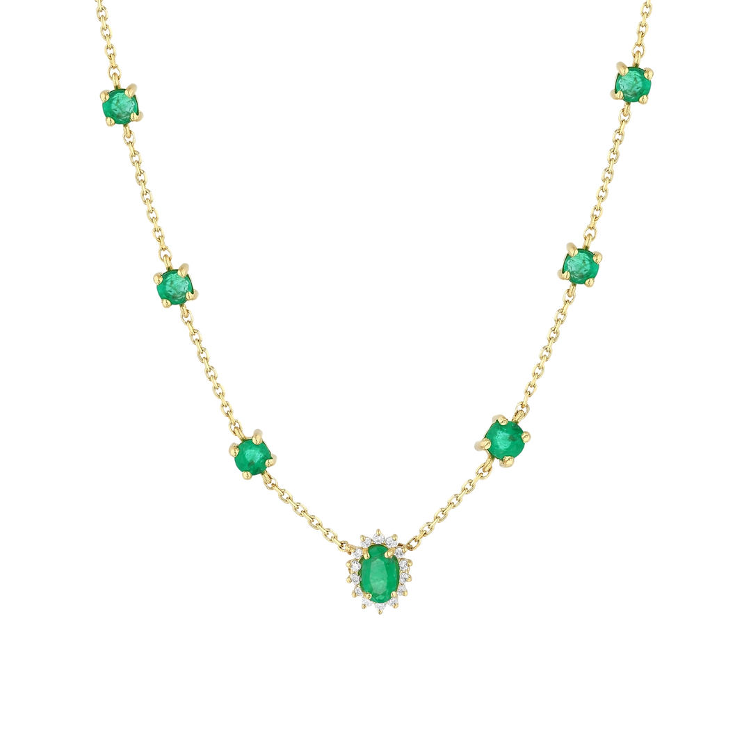 Close-up of the oval emerald in a natural diamond halo and the round emerald stations in 14K yellow gold