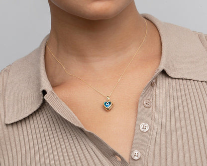 Front view on model of the 14K solid gold evil eye heart pendant.