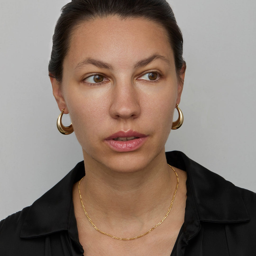 Gold figaro chain necklace at collarbone length
