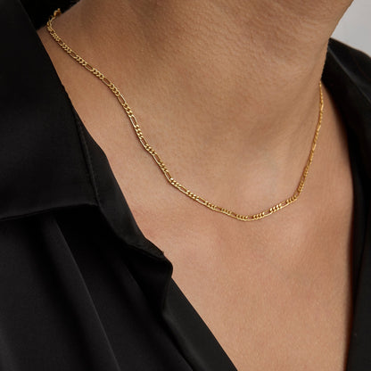 Gold figaro chain necklace worn on the neck