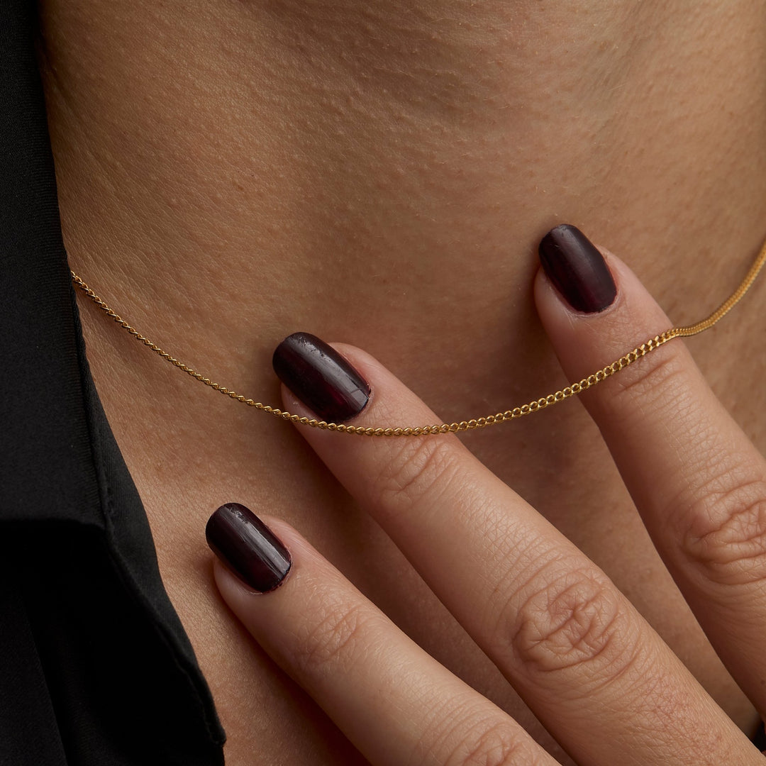 Close up of the 1.5 mm flat curb links on the gold chain necklace