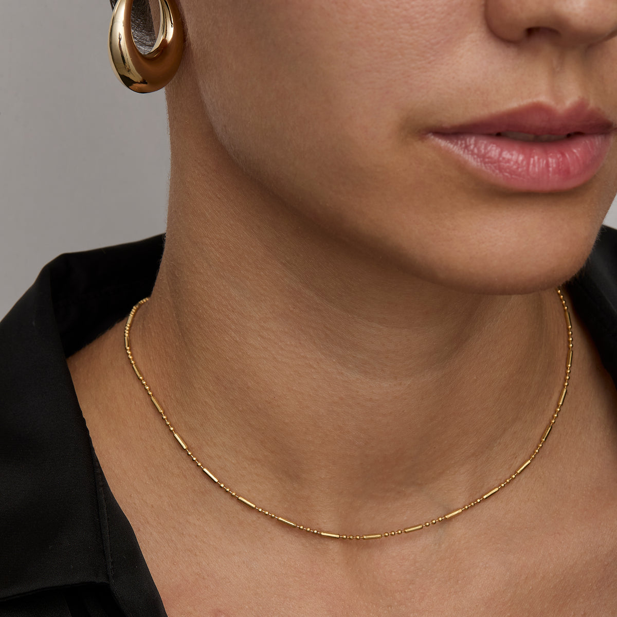 Gold flat link chain necklace at collarbone length