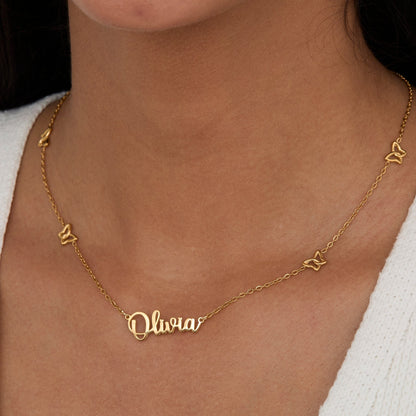 Close-up of the Gold Butterfly Name Necklace — script nameplate with butterfly charms along the chain.