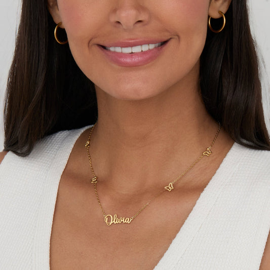 Gold Butterfly Name Necklace worn close-up — personalized script name with open gold butterfly charms.