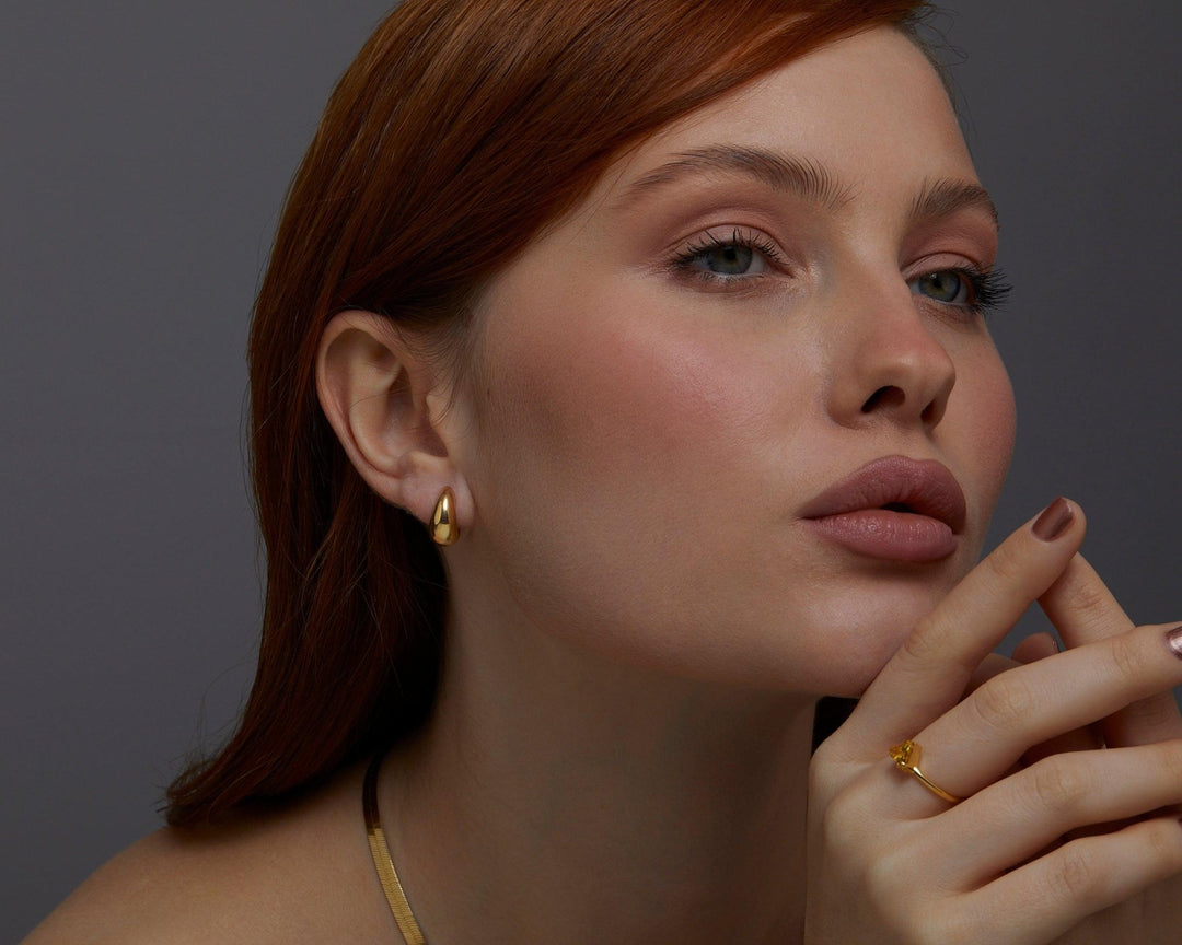 The Gold Hinged Huggie Earrings styled in 18K Gold Vermeil — elegant everyday jewelry. Hypoallergenic for sensitive ears.