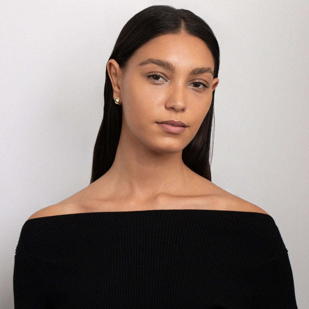 The Gold Huggie Hoop Earrings styled in Gold-Plated Steel — elegant everyday jewelry. Hypoallergenic for sensitive ears.