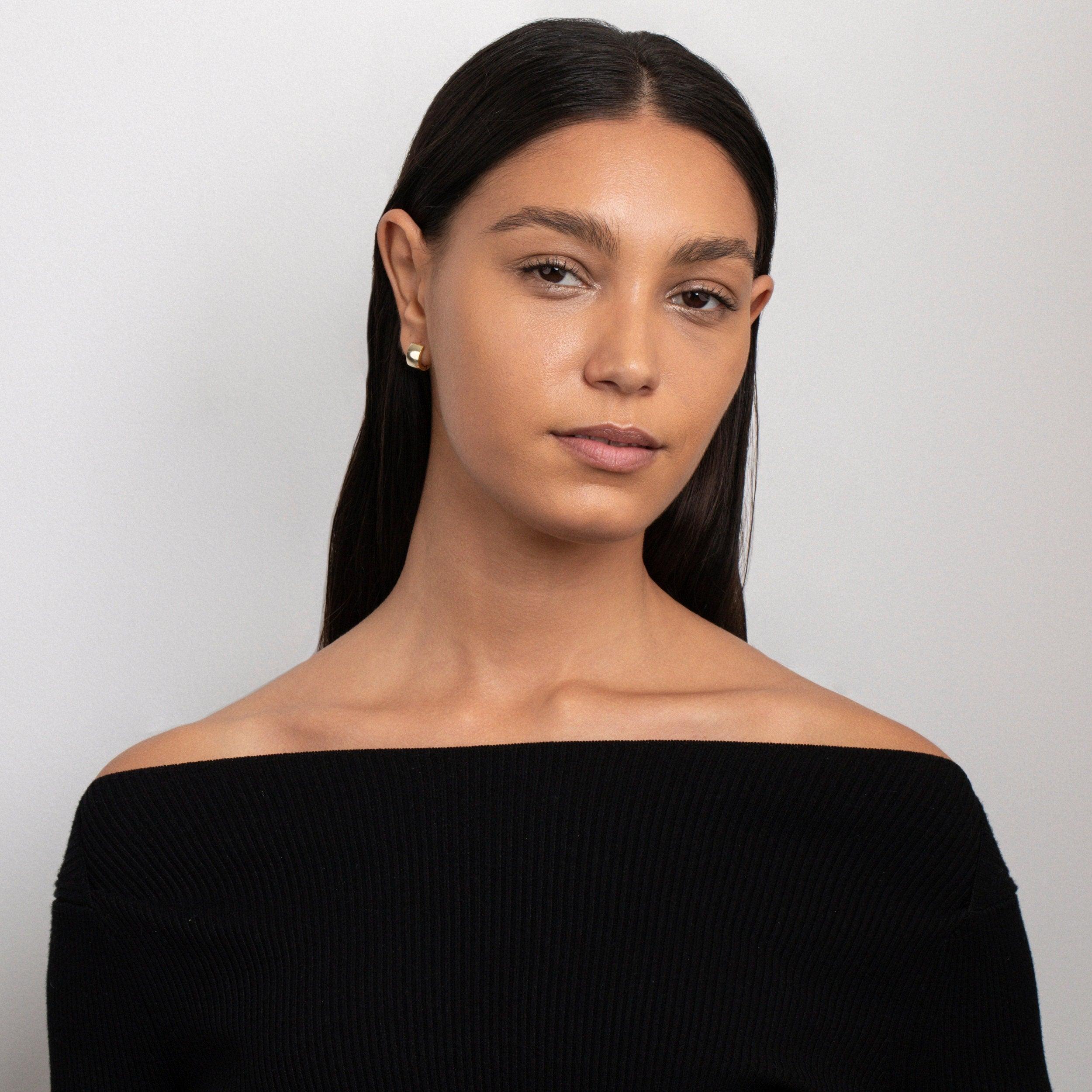 The Gold Huggie Hoop Earrings styled in Gold-Plated Steel — elegant everyday jewelry. Hypoallergenic for sensitive ears.