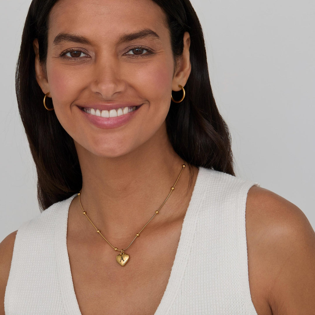 The Heart Initial Engraved Necklace styled in Gold-Plated Steel — elegant everyday jewelry. Hypoallergenic, no green marks.