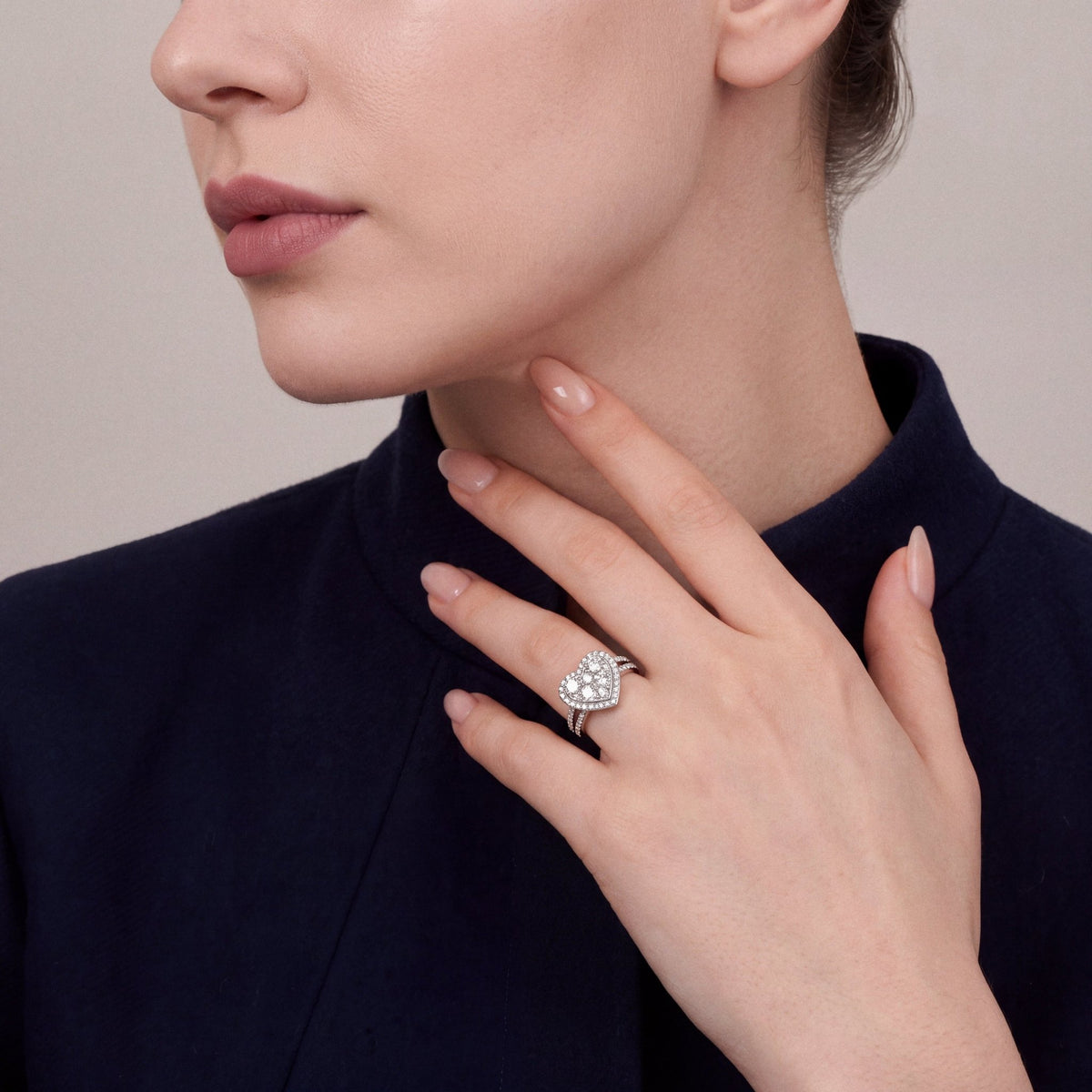 Woman in a navy mandarin-collar jacket wearing a 1.59 ct natural diamond heart cluster ring in 14K white gold on the ring finger, fingertips at the neck