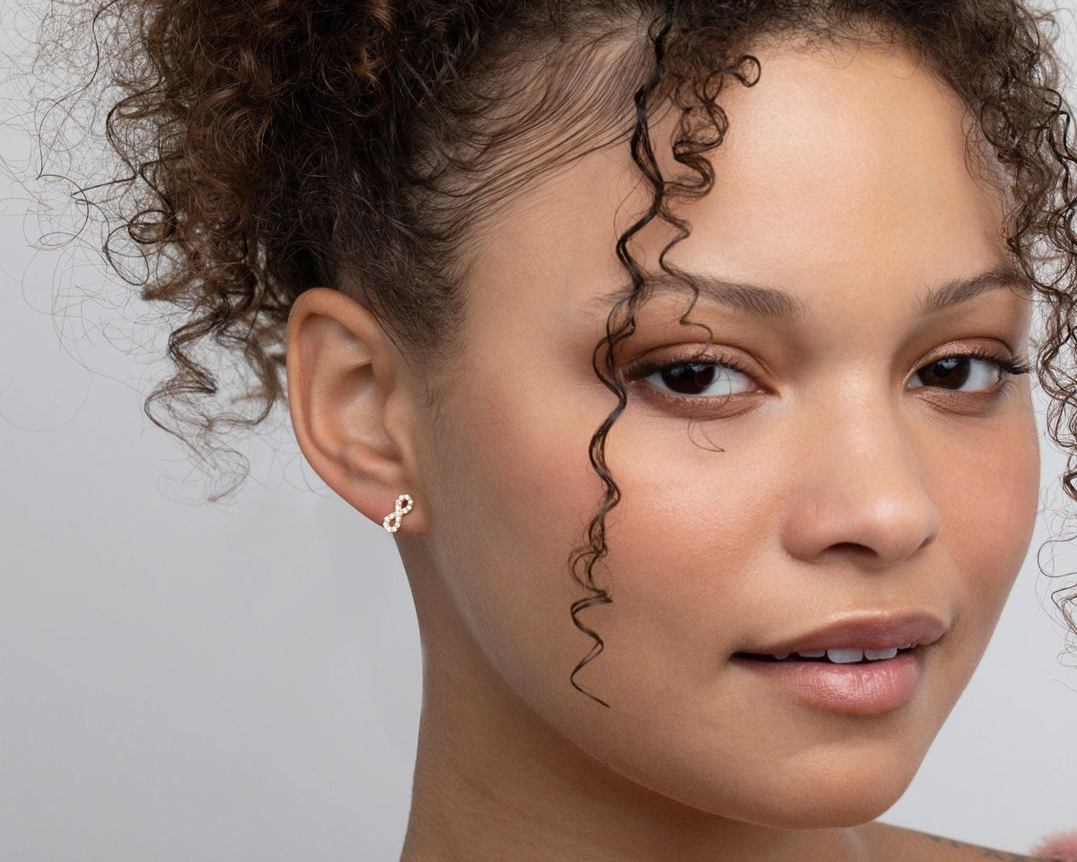 The Infinity Earrings with CZ Diamonds styled in 18K Gold Vermeil — elegant everyday jewelry. Hypoallergenic for sensitive.