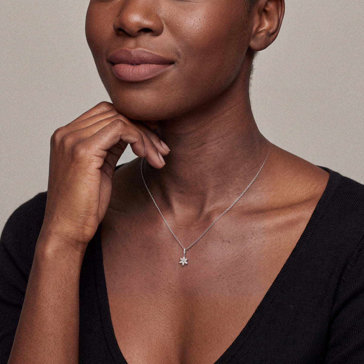Model wearing the marquise diamond flower pendant necklace in 14K white gold with a black knit top