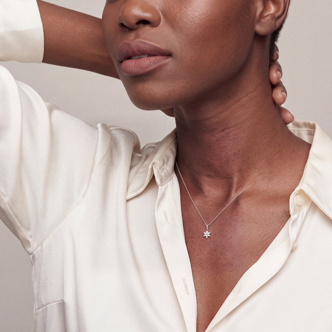 Model wearing the marquise diamond flower pendant necklace in 14K white gold with an ivory silk shirt