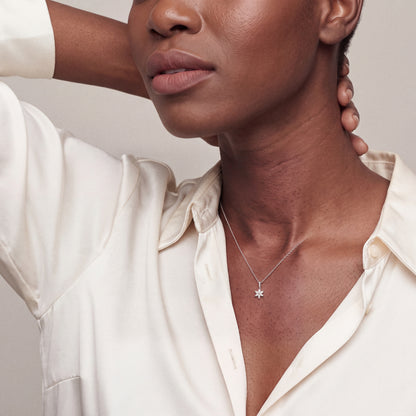 Model wearing the marquise diamond flower pendant necklace in 14K white gold with an ivory silk shirt