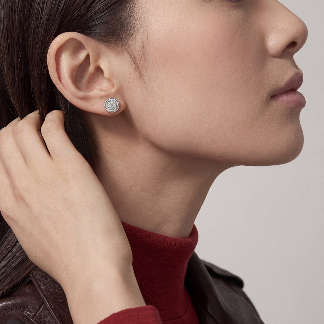 Model wearing the diamond cluster stud earring, hand tucking her hair behind the ear