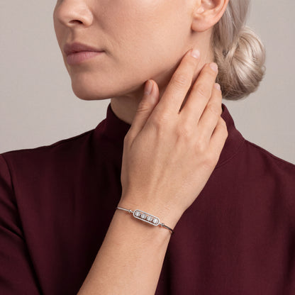 Woman in an oxblood high-neck top wearing a natural diamond baguette bar bangle in 18K white gold