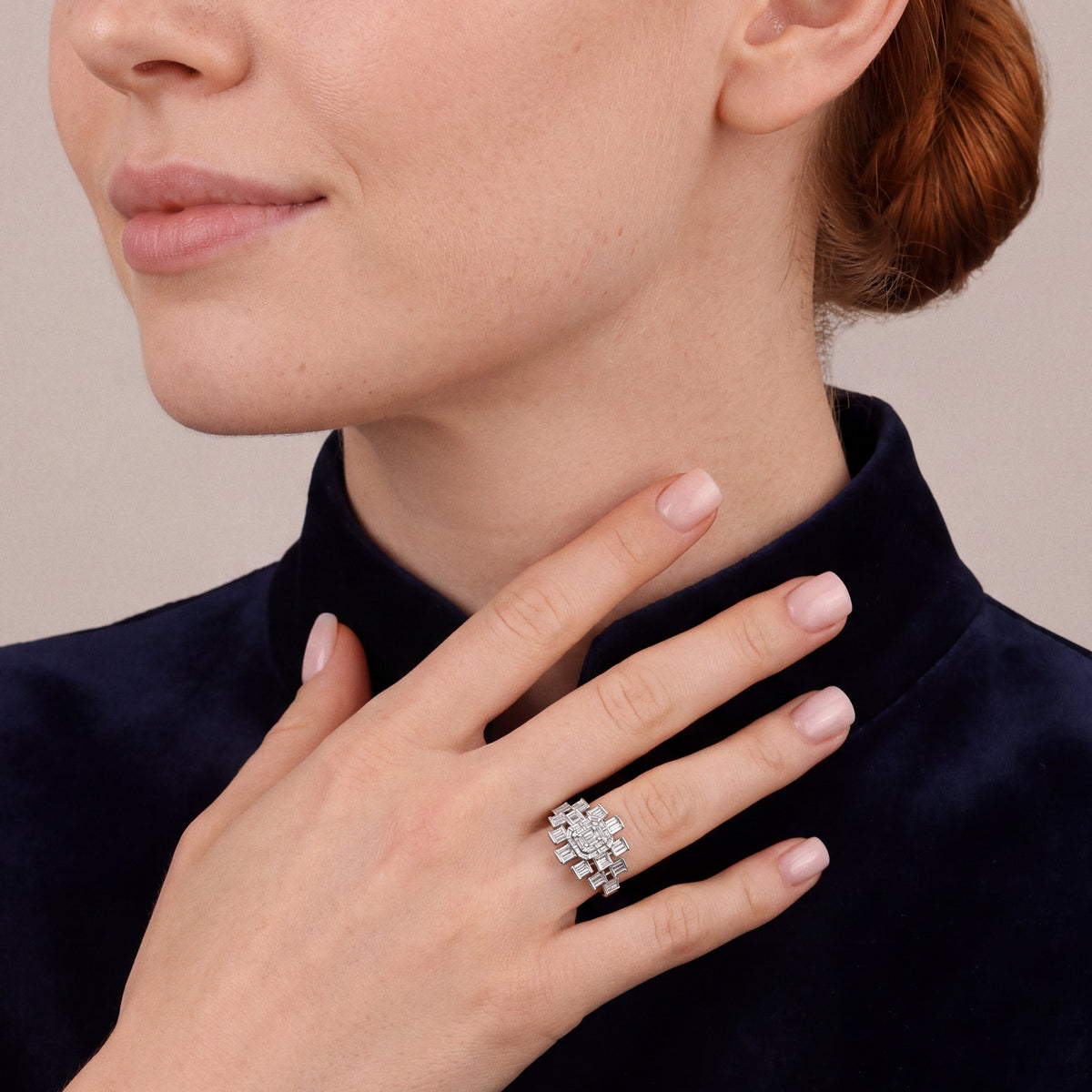 Woman in a midnight-navy velvet jacket wearing a 1.06 ct natural diamond baguette cluster cocktail ring in 14K white gold on the ring finger, fingertips at the base of the neck