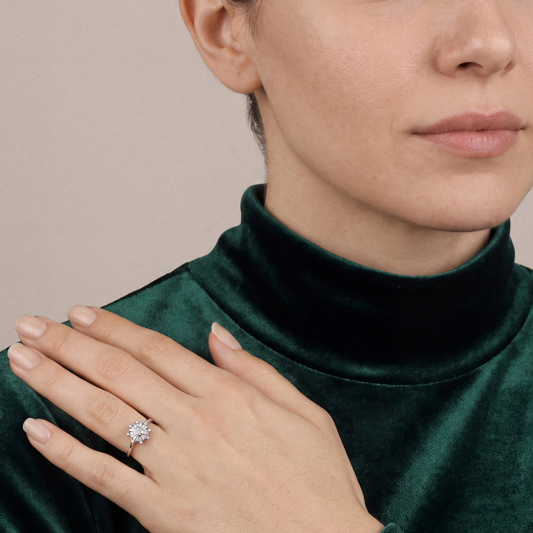 Woman in an emerald velvet funnel-neck top wearing a natural diamond snowflake ring in 14K white gold, hand laid on her shoulder