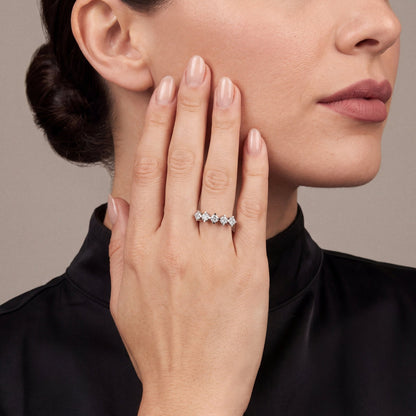 Natural diamond five-stone crown ring in 14K white gold worn on the ring finger, palm resting on the cheek, black silk high-neck top