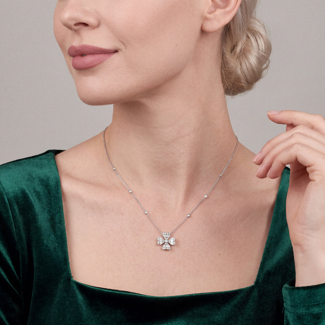Woman in an emerald velvet top wearing the natural diamond heart clover pendant necklace in 18K white gold