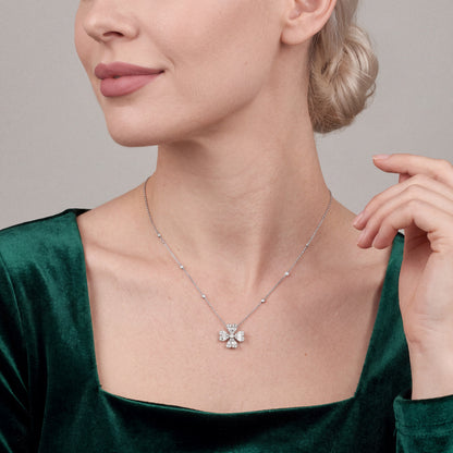 Woman in an emerald velvet top wearing the natural diamond heart clover pendant necklace in 18K white gold