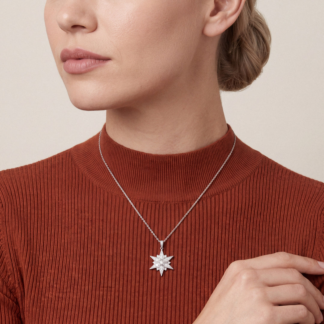 Woman in a rust mock-neck knit wearing the natural diamond pavé starburst pendant necklace in 14K white gold